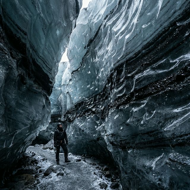 Interior of Katla Ice Cave showing black volcanic ash layers frozen in the ice
